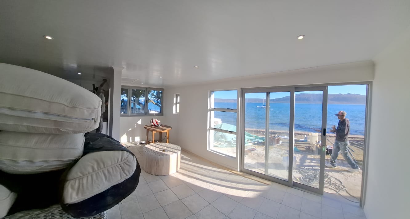 A bright tiled interior with aluminium sliding doors overlooking the sea