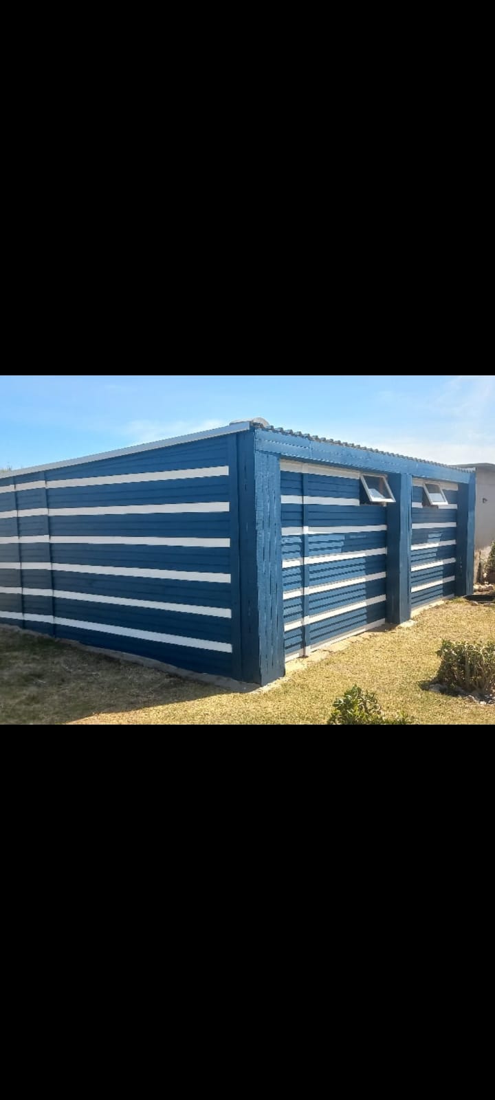 A custom blue and white painted Nutec structure with awning windows
