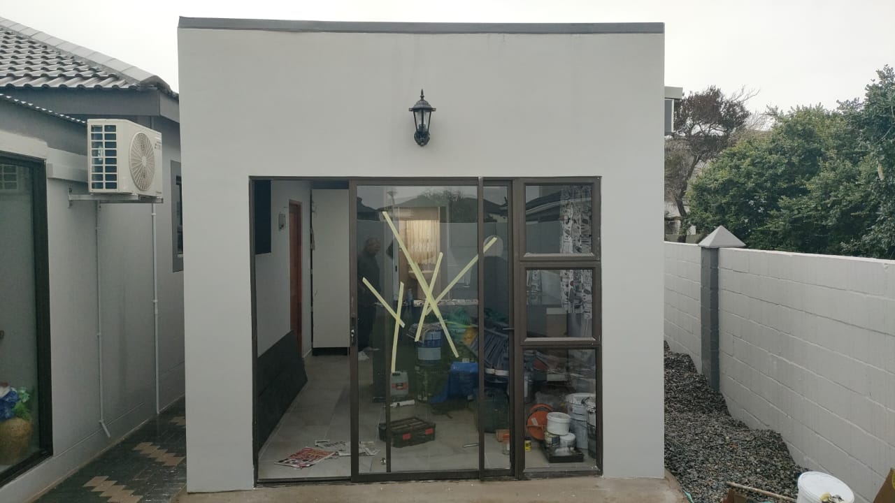 A modern flat-roof structure with aluminium sliding doors and windows